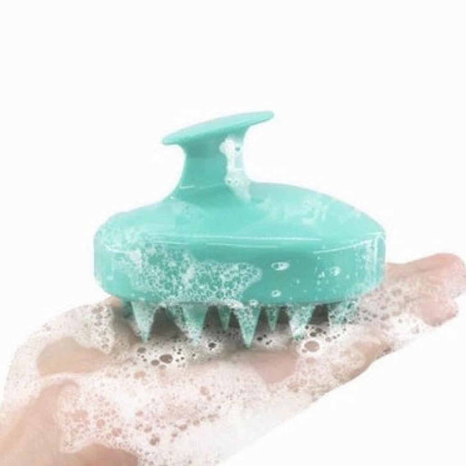 Blue silicone scalp massager brush in a hand with shampoo foam