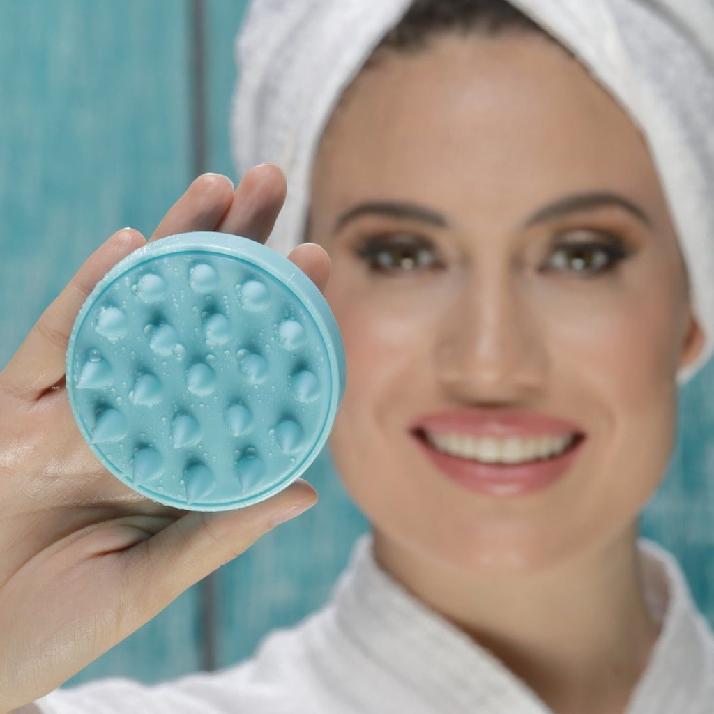 Woman holding a blue silicone scalp massager brush